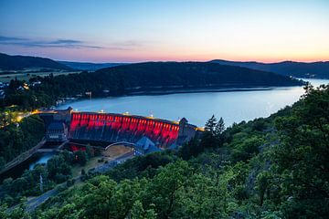 Edersee und rot beleuchteter Staudamm im Sonnenuntergang