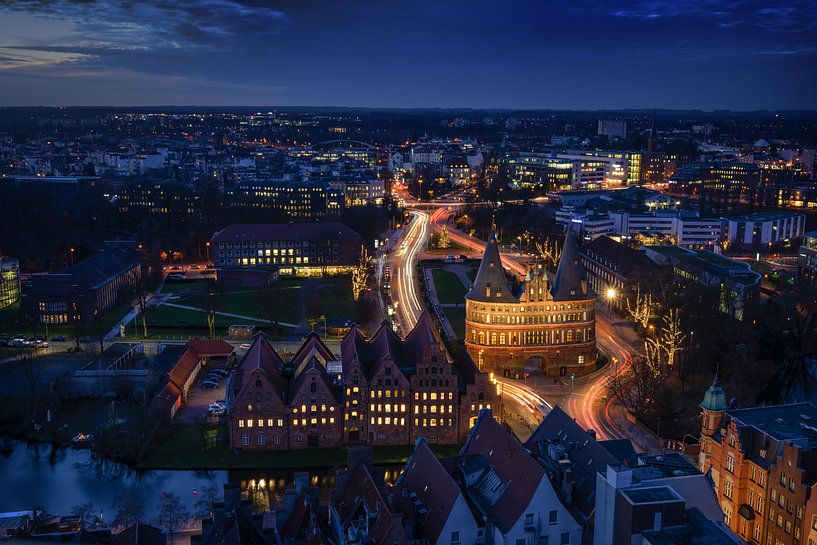Luftnachtaufnahme der beleuchteten Stadt Lübeck im Winter mit Holstentor und historischen Salzspeich von Maren Winter