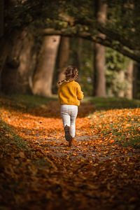 Image d'ambiance automnale d'une fille courant avec des tresses dans les bois. sur Mayra Fotografie