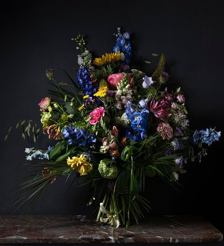 Stilleven van kleurrijke bloemen met een zwarte achtergrond en een marmeren tafel