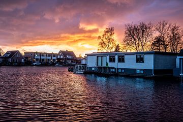 Alsof er brand is achter de huizen, zon gaat onder, woeste wolken, vele kleuren van Jan Willem de Groot Photography