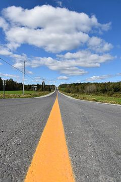 Une route de campagne sous un ciel bleu sur Claude Laprise