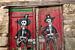 Rode deuren van schuur in Spaanse dorpje Miranda del Castanar met tekening van twee skelet cowboys van Joost Adriaanse