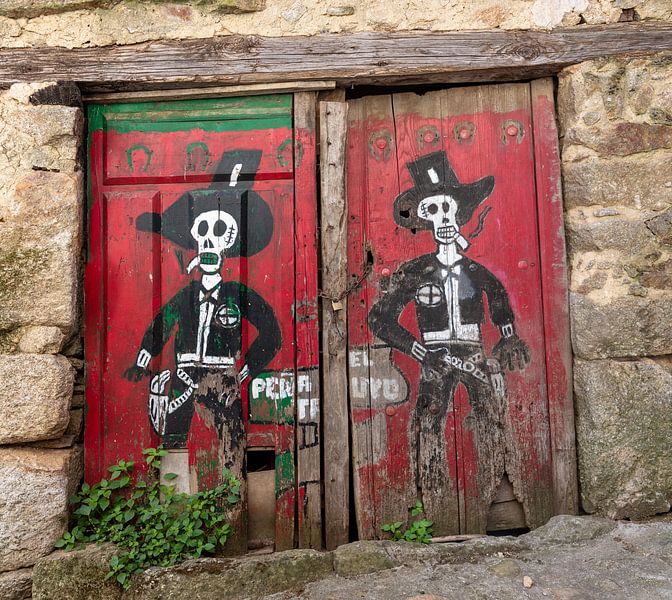 Portes rouges d'une grange dans le village espagnol de Miranda del Castanar avec le dessin de deux c par Joost Adriaanse