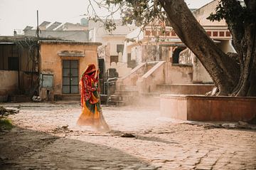 Frau fegt bei Sonnenaufgang die Straße in Jaipur von Ayla Maagdenberg