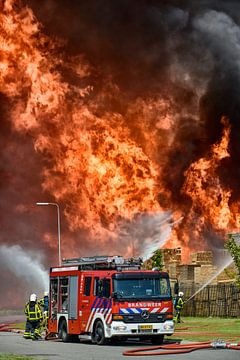Fire engine in front of a fire in an industrial area