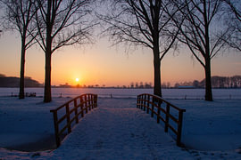 A stunning view of a snow-covered meadow at sunset by Sabine van Gool