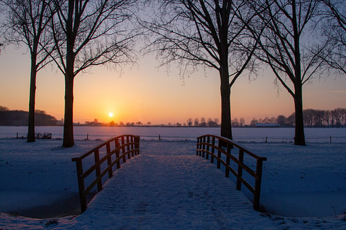 Wunderschöner Blick auf eine verschneite Wiese bei Sonnenuntergang