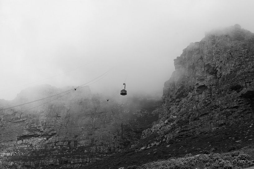 Zwart-wit beeld van kabelbaan in de mist van de Tafelberg in Zuid-Afrika von Romy Wieffer