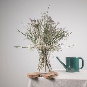 Vase mit Blumen und Gießkanne