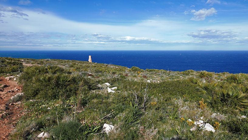 Zicht op de antieke vuurtoren Torre del Gerro aan de kust bij Denia. van Gert Bunt
