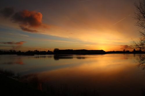 Oranje wolken reflecteren op het water van de Hollandsche IJssel tijdens zonsopkomst