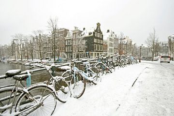 Besneeuwde fietsen op de grachten in Amsterdam in de winter van Eye on You