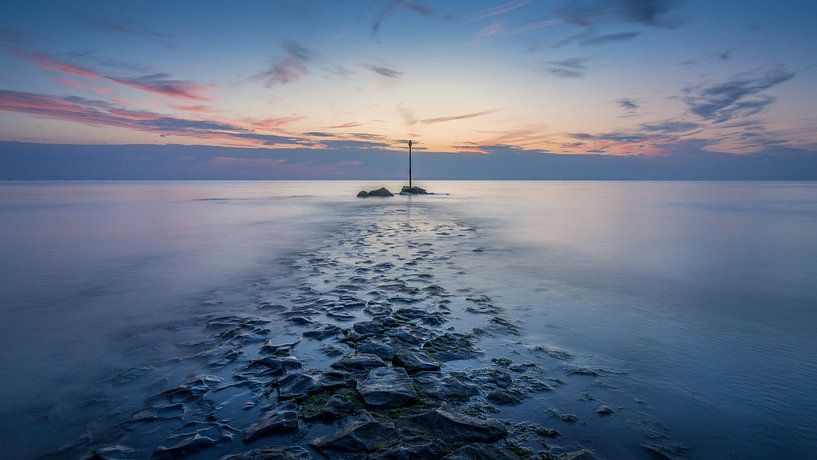 Beacon in the sea at Scheveningen during blue hour with orange glow by Silvia Thiel