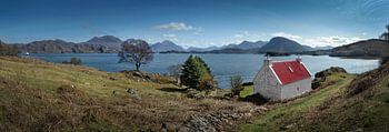Panoramafoto von weißem Cottage mit rotem Dach am Loch Claira in den schottischen Highlands.