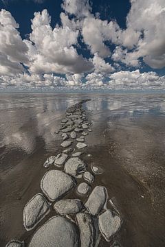 Brise-lames usé dans la mer des Wadden avec un paysage de nuages néerlandais.