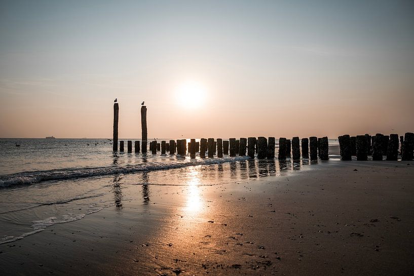 Zonsondergang aan het Strand met Golfbrekers van Femke Ketelaar