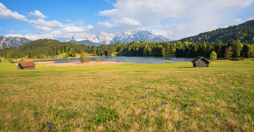 beautiful view to lake Geroldsee and karwendel mountains, green pasture with wooden huts and blue ge by SusaZoom