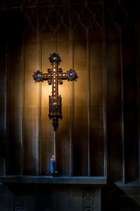 Metal crucifix with a burning candle in a small old church in Devon, United Kingdom sur Hein Fleuren