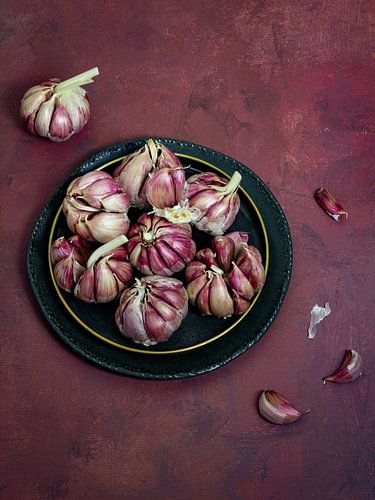 Still life, Garlic bulbs (Allium sativum) in modern Bordeaux red by Oda Slofstra