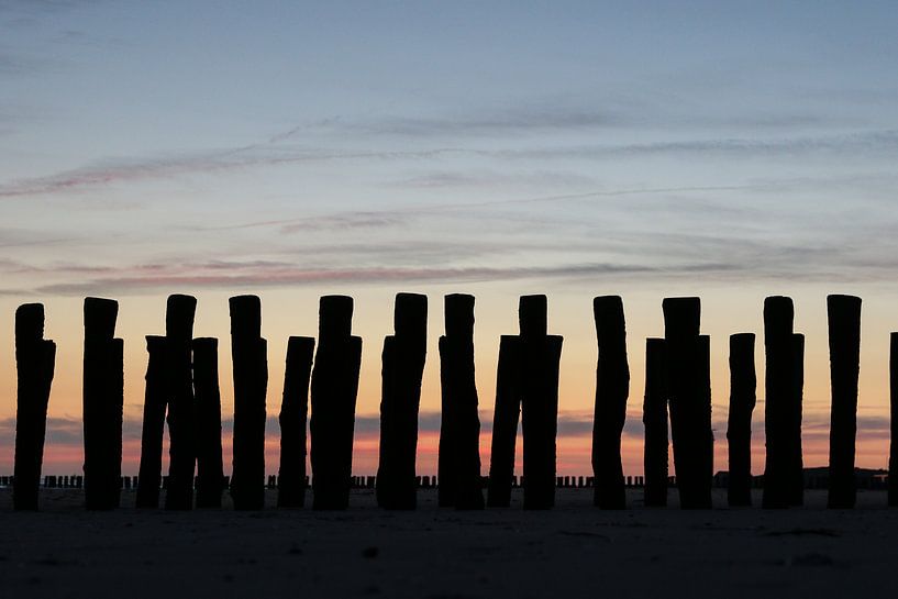 golfbrekers met ondergaande zon op het strand in zeeland by Frans Versteden