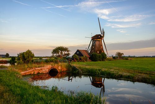Molen langs het water op het platteland