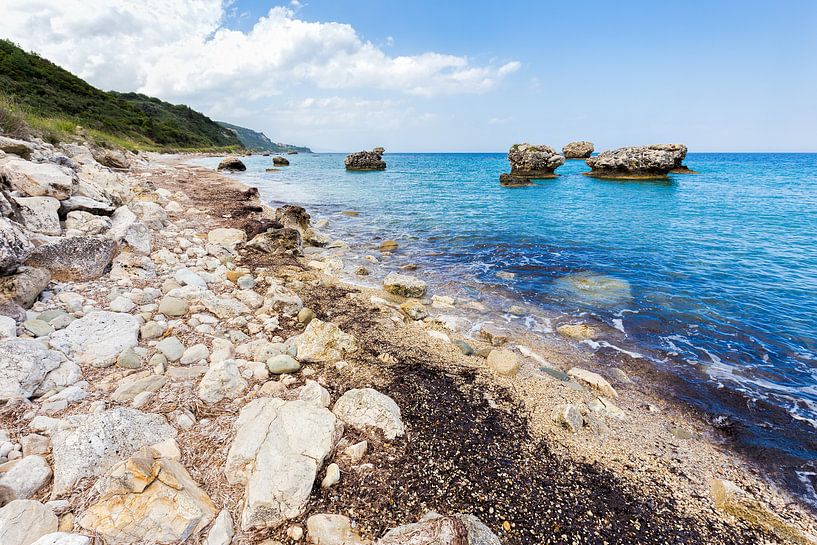 Greek landscape with boulders and rocks on coast with blue sea by Ben Schonewille