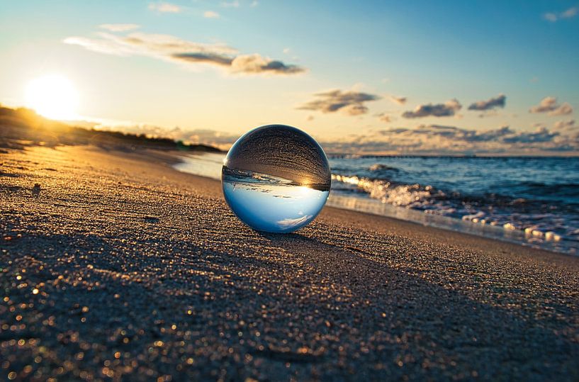 View through the glass ball on the beach. Sea and sky in the background. by Martin Köbsch