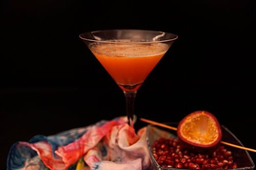 Cocktail met passievruchtensap, sinaasappellikeur, cranberrysap, wodka en verse passievrucht.