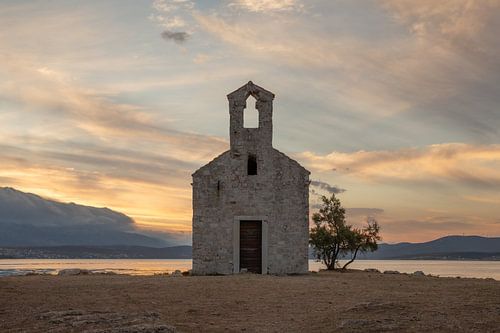 Een zomerse zonsopkomst bij een oud kerkje aan de Kroatische kust
