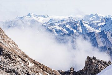 Sfeervolle compositie van hoge bergtoppen in de wolken. Een combinatie van warme en koude kleuren