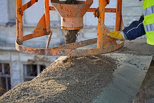 Bouw van een betonnen ring om een gebouw te beveiligen na gedeeltelijke sloop van een pakhuis.