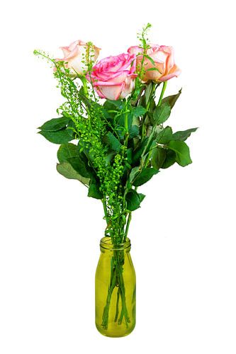 Boeket bloemen in een glazen vaas op een witte achtergrond