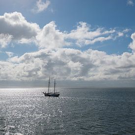 Sun over the Wadden Sea with sailing boat by Tonko Oosterink