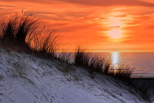 Orange sky at sunset with sea shore coast and dune