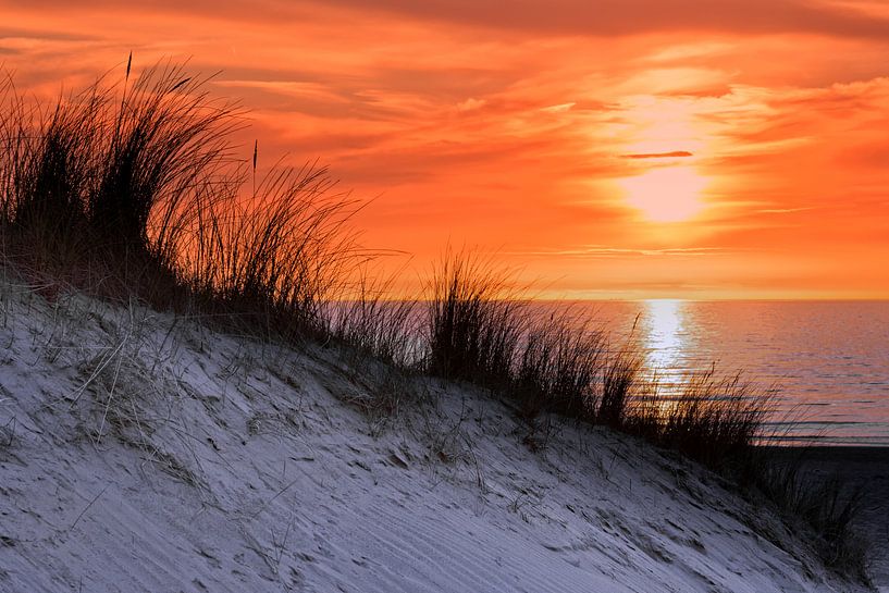 Orange Himmel bei Sonnenuntergang am Meer mit Dünen und Gras von Ben Schonewille