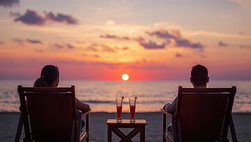 A couple sits on the beach at sunset. by Bo Valentino