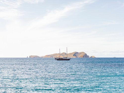 Een zeilboot liggend in de diepblauwe middellandse zee bij Ibiza