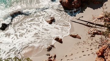 Voetstappen in het zand met kalmerende zee op Ibiza van Slow ibiza