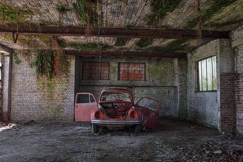 Urbex kleine rode auto in een vervallen garage.