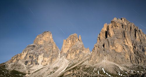 Het Langkofelmassief bij nacht, met sterrensporen tussen de wolken van Sean Vos