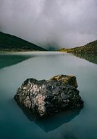Bergsee am Gletscher mit Fels im Kaukasusgebirge in Georgien an grauem, dunklem Tag