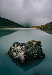 Bergsee am Gletscher mit Fels im Kaukasusgebirge in Georgien an grauem, dunklem Tag von Robin Patijn