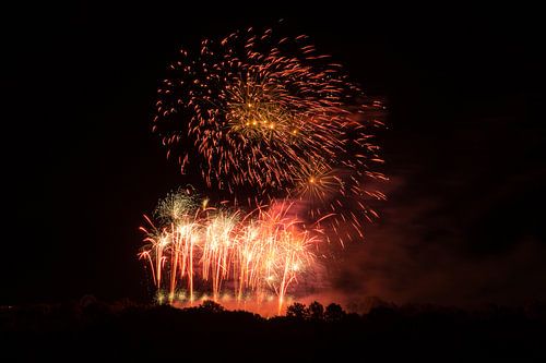 Rode vuurballen van vuurwerkexplosies in prachtig licht bij nacht