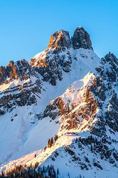 A winter mountain landscape in the warm light of the setting sun.