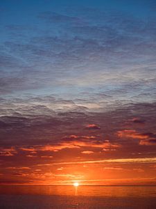 Zonsopkomst boven de Waddenzee van Laurens de Waard