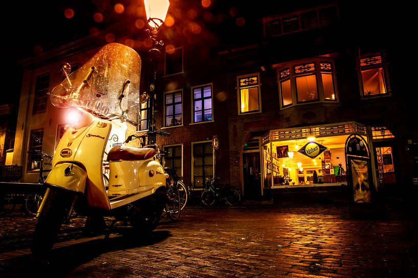 Une soirée d'achat pluvieuse, le magasin de disques Velvet est ouvert. Une Vespa complète le tableau par Hans de Waay