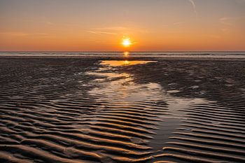 Zonsondergang strand met weerspiegeling