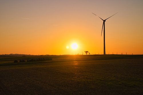 Windturbine bij zonsondergang op een weiland