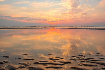 Sommerlicher Sonnenuntergang am Nordseestrand mit einem Wellenmuster im Sand